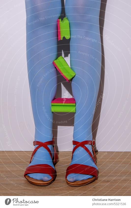 Beine - Knie abwärts - in blauer Strumpfhose und roten Sandalen mit eingeklemmten grünen Putz-Schwämmen Frau Hausarbeit putzen Haushalt Übermut Hausfrau zuhause