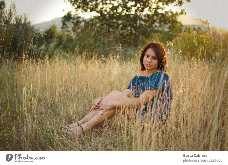 Frau sitzt im Gras und betrachtet die Natur. sich[Akk] entspannen entspannende Zeit Lifestyle Porträt Mädchen natürlich Landschaft jung Menschen aussruhen