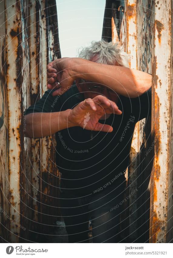 Lost Land Love II in der Klemme zwischen alten rostigen Container Mann Mensch Körperhaltung Hand gestikulieren Schatten Schutz Vorsicht beschützt