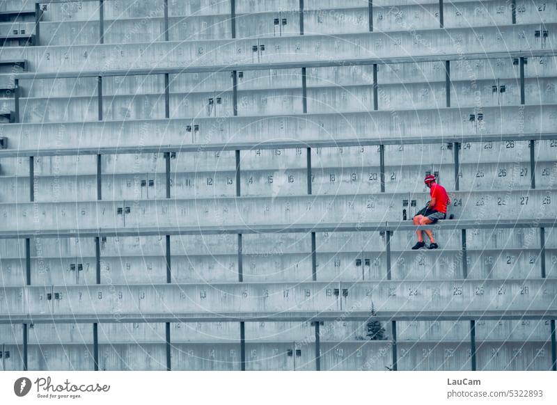 Pause im Stadion Leere Ränge Mann Person grau Beton rot rote Person Stufen Geländer Treppengeländer freie Platzwahl Reihen Strukturen & Formen Linien leer