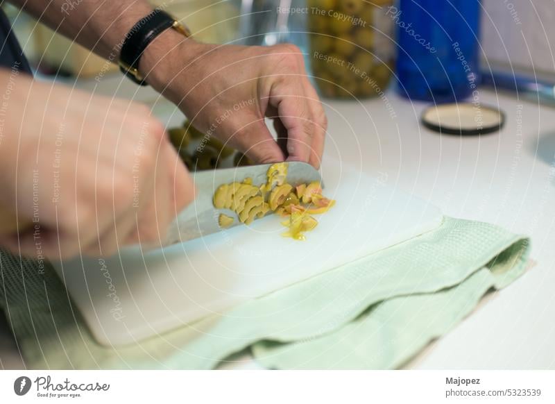 Männerhände schneiden Oliven. Japanisches Messer Menschen Bestandteil geschnitten menschlich Küche Arbeit Küchenchef Hintergrund Kaukasier abschließen