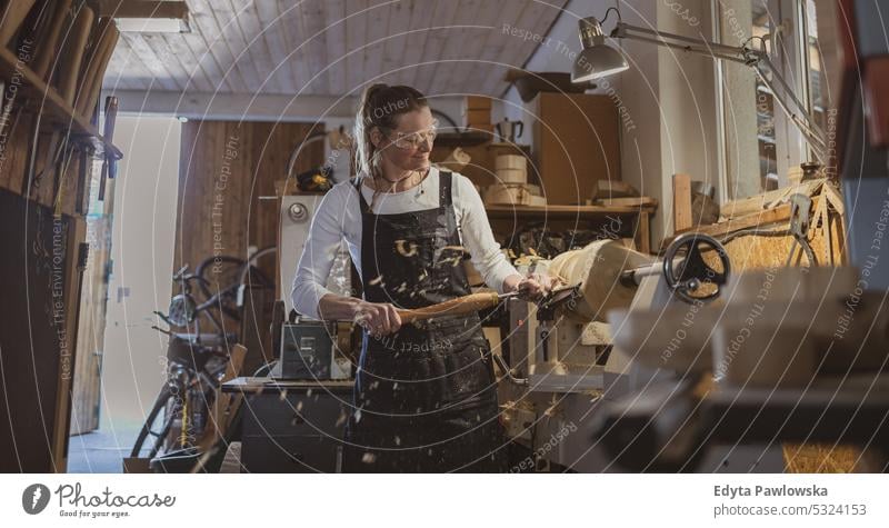 Handwerkerin beim Schnitzen von Holz in einer Schreinerei echte Menschen Holzwerkstatt Zimmerer Unternehmer Kompetenz Werkstatt Kreativität Herstellung Hobby