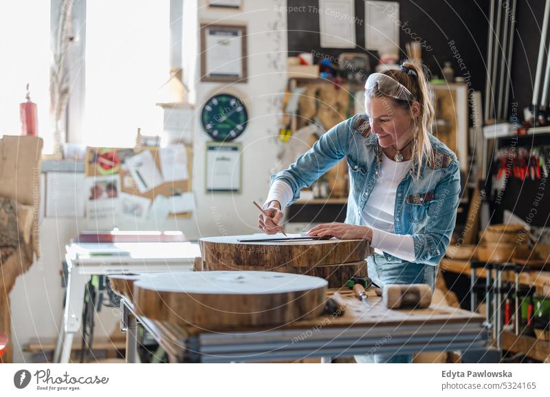 Handwerkerin bei der Arbeit mit Holz in einer Schreinerwerkstatt echte Menschen Holzwerkstatt Zimmerer Unternehmer Kompetenz Werkstatt Kreativität Inszenierung