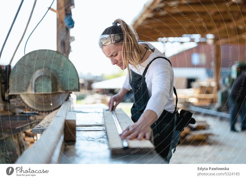 Frau arbeitet mit Holzbrettern in einem Sägewerk echte Menschen Holzwerkstatt Zimmerer Unternehmer Kompetenz Werkstatt Handwerker Kreativität Herstellung Hobby