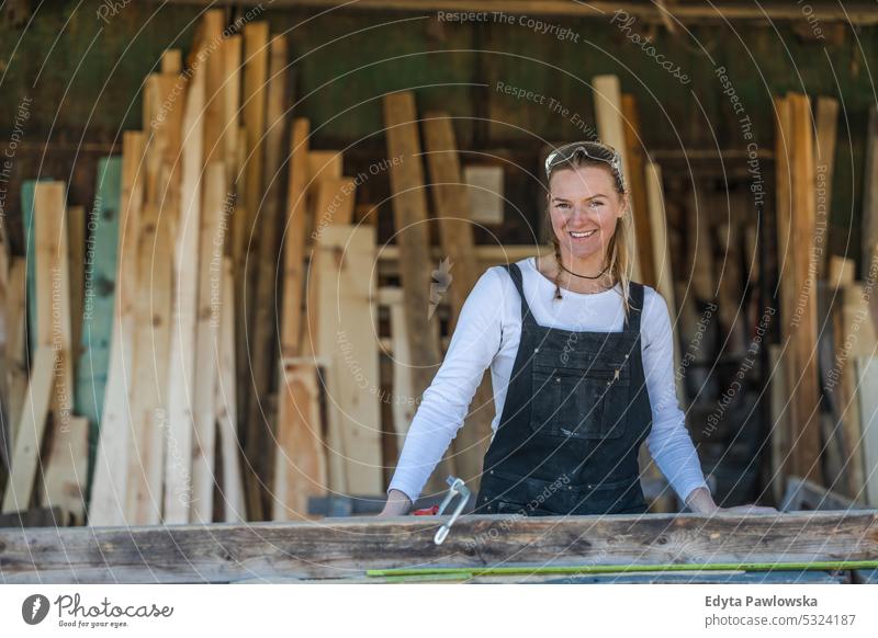 Frau arbeitet mit Holzbrettern in einem Sägewerk echte Menschen Holzwerkstatt Zimmerer Unternehmer Kompetenz Werkstatt Handwerker Kreativität Herstellung Hobby