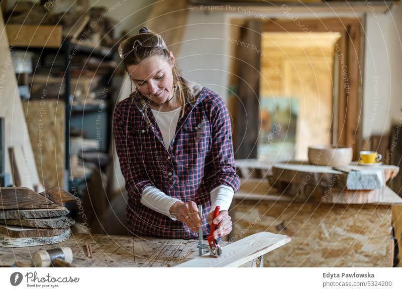 Handwerkerin bei der Arbeit mit Holz in einer Schreinerei echte Menschen Holzwerkstatt Zimmerer Unternehmer Kompetenz Werkstatt Kreativität Herstellung Hobby