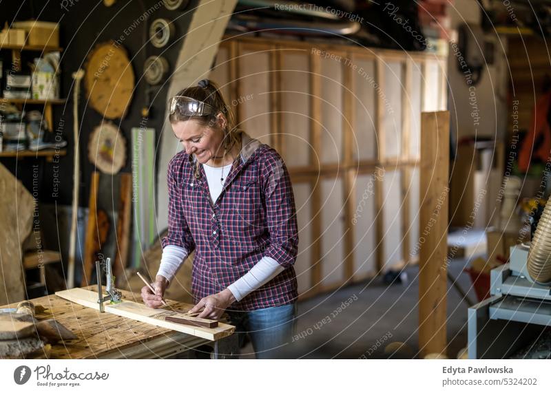 Handwerkerin bei der Arbeit mit Holz in einer Schreinerei echte Menschen Holzwerkstatt Zimmerer Unternehmer Kompetenz Werkstatt Kreativität Herstellung Hobby