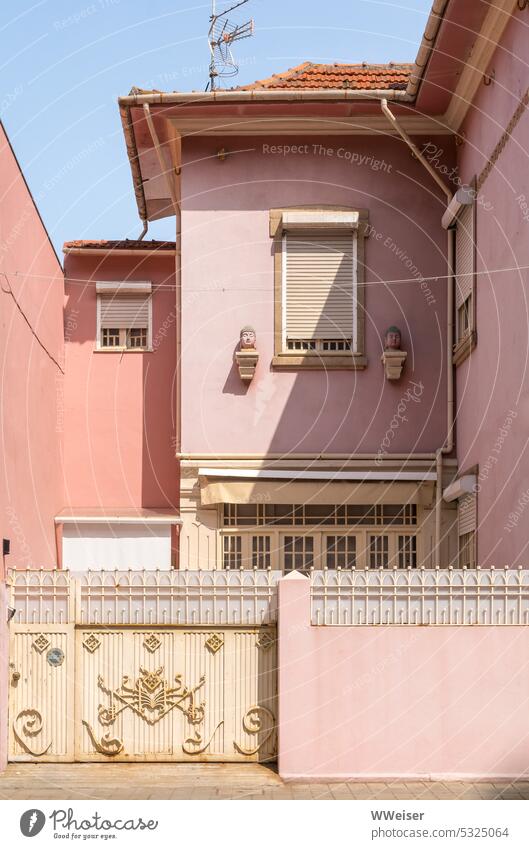 Fassaden alter Häuser in weichen Rosa- und Rottönen hinter einem verzierten Zaun Stadt wohnen Wohnhaus Haus rosa orange rot warm Farben harmonisch Hof