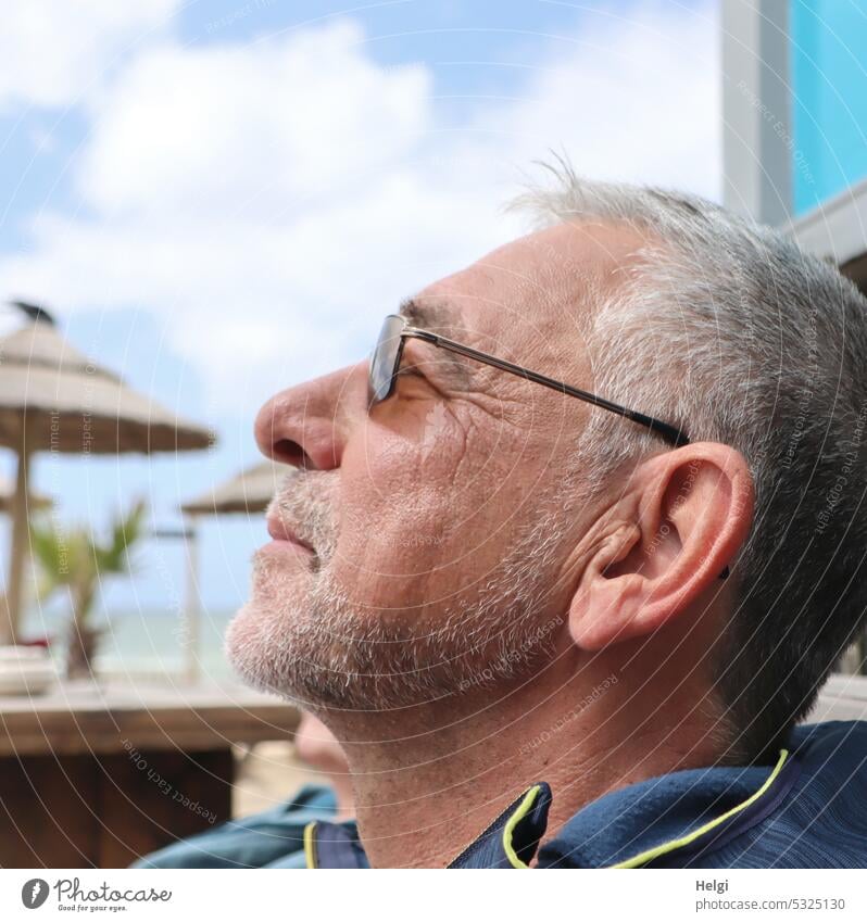 Sonne genießen - Porträt eines grauhaarigen Senioren mit Dreitagebart und Sonnenbrille im Profil Mensch Mann Kopf Gesicht kurzhaarig Strand Frühling