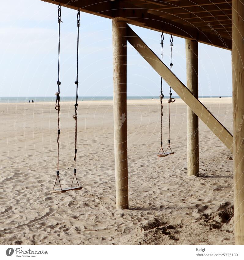 zwei Schaukeln an einem Pfahlbau am Strand Sand Küste Nordseeküste Holland Niederlande Meer Holz hängen Himmel Wasser Ferien Erholung Urlaub