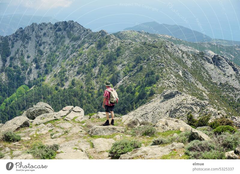 Wanderer mit Rucksack und Wanderhut  blickt vom Monte Capanne aus über die Insel Elba Berg Italien Blog Mittelmeer Thyrrenisches Meer Toskanischer Archipel