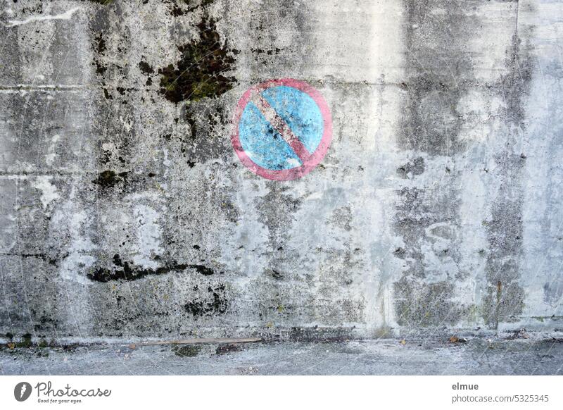 ein gemaltes und sich langsam auflösendes Verkehrszeichen - eingeschränktes Halteverbot - an einer grauen alten Wand Parkverbot parken verboten Verkehrsschild