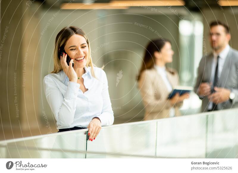 Junge Geschäftsfrau mit Mobiltelefon im Büroflur Erwachsener Assistent Business Geschäftsmann Geschäftsleute Karriere Kaukasier Kollegen Unternehmen