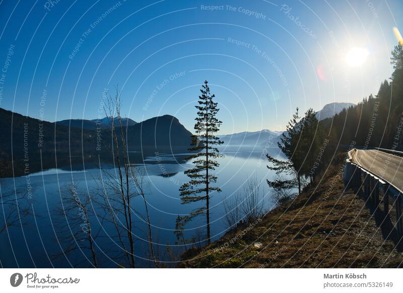 Blick auf den See Oppstrynsvatnet in Norwegen in den Morgenstunden. Schneebedeckte Berge Gebirgssee Skandinavien Sonnenschein Frühnebel Reflexion & Spiegelung