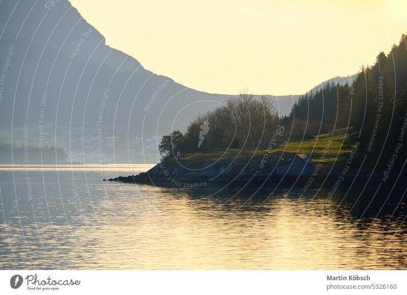 Sonnenuntergang an einem Fjord mit Bergen in Norwegen. Diffuses Licht, Sonnenstrahlen auf einer Wiese Berge u. Gebirge Erholung Natur Wildnis Panorama