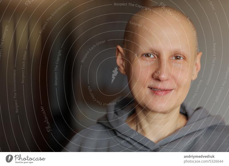 Lächelnde haarlose junge Patientin, die mit der Onkologie zu kämpfen hat, schaut in die Kamera zu Hause. Bald Krebs kranke Frau nach der Chemotherapie verloren ihre Augenbrauen und Wimpern fühlen sich optimistisch der Erholung Remission