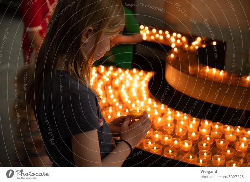 Mädchen zündet eine Kerze in einer Kirche an Glaube Kindheit Hoffnung Spiritualität Familie Licht Advent Beten Gebet katholisch Gottesdienst