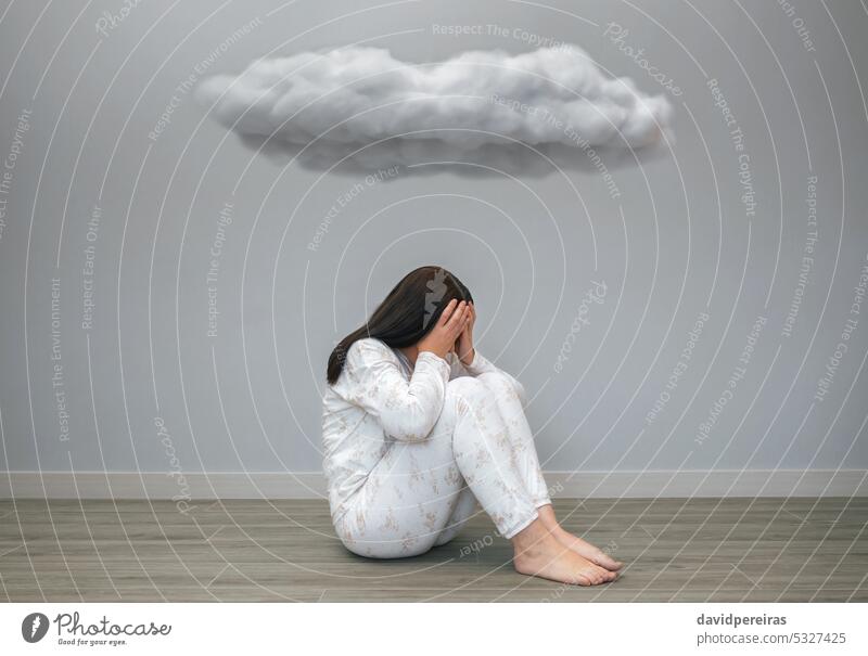 Frau mit psychischen Problemen, die unter einer dunklen Wolke ihr Gesicht mit den Händen bedeckt unkenntlich verzweifelt Problematik mental Gesundheit Angst