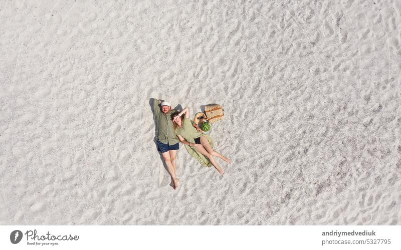 Luftaufnahme eines jungen Paares, das auf dem weißen Sand liegt. Mann und Frau verbringen Zeit miteinander und reisen durch die Wüste Lügen Antenne Strand