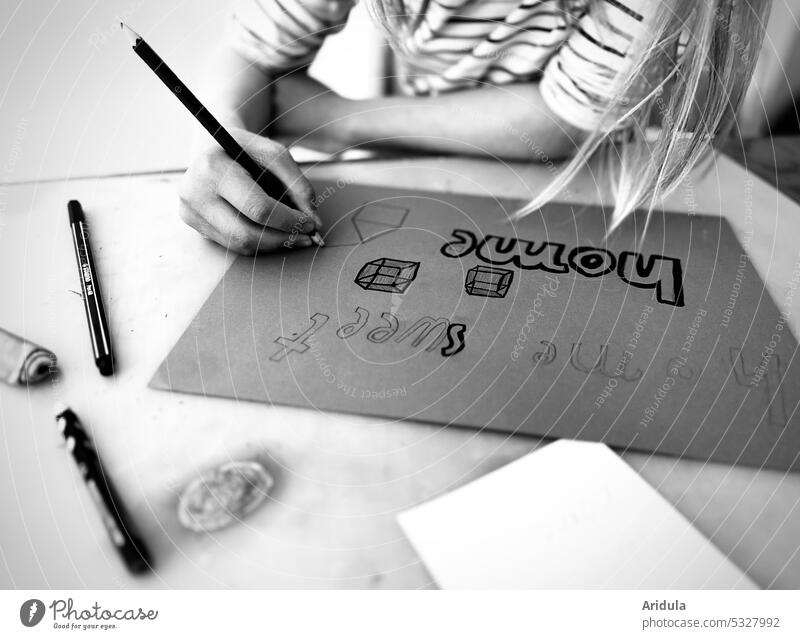 „home sweet home“ | Kind sitzt am Tisch und schreibt und zeichnet s/w No. 1 zeichnen schreiben Kreativität Stift Hand Zettel zuhause Papier Kindheit lernen