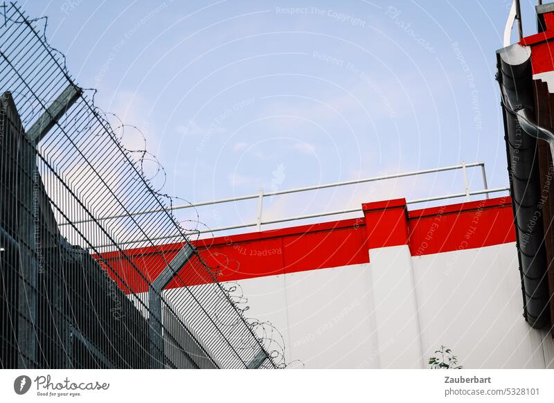 Zaun mit Stacheldraht, Mauer mit rotem Steifen, Rückseite eines Supermarkts einblick Sicherheit abstrakt urban Barriere Schutz Grenze bedrohlich gefangen