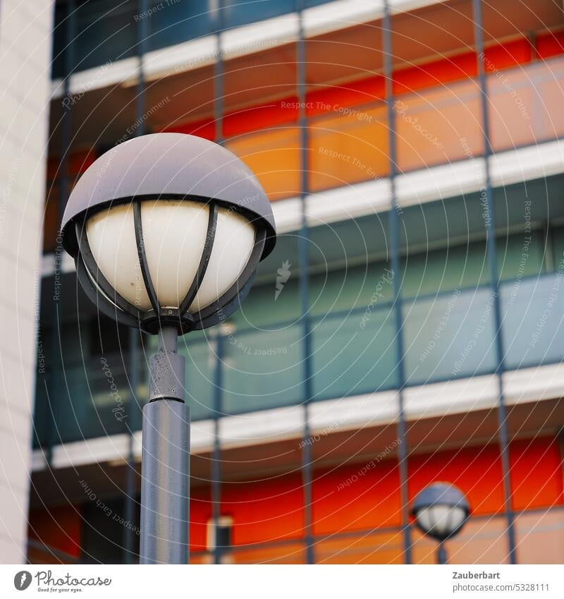 Straßenlaterne vor rot-grauer, rechteckig gegliederter Fassade straßenbeleuchtung 70er 60er modern architektur urban öde banal farbig