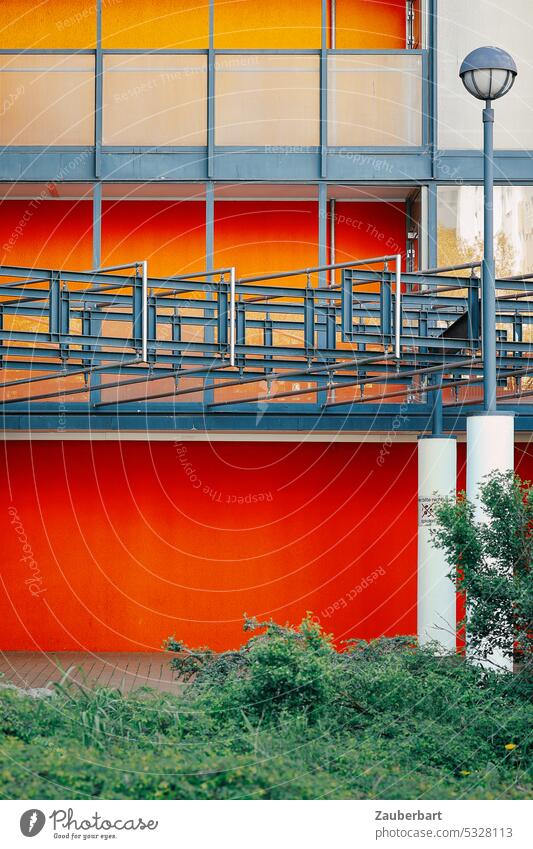 Straßenlaterne vor rot-grauer, rechteckig gegliederter Fassade straßenbeleuchtung 70er 60er modern architektur urban öde banal farbig Stahl gitter technisch