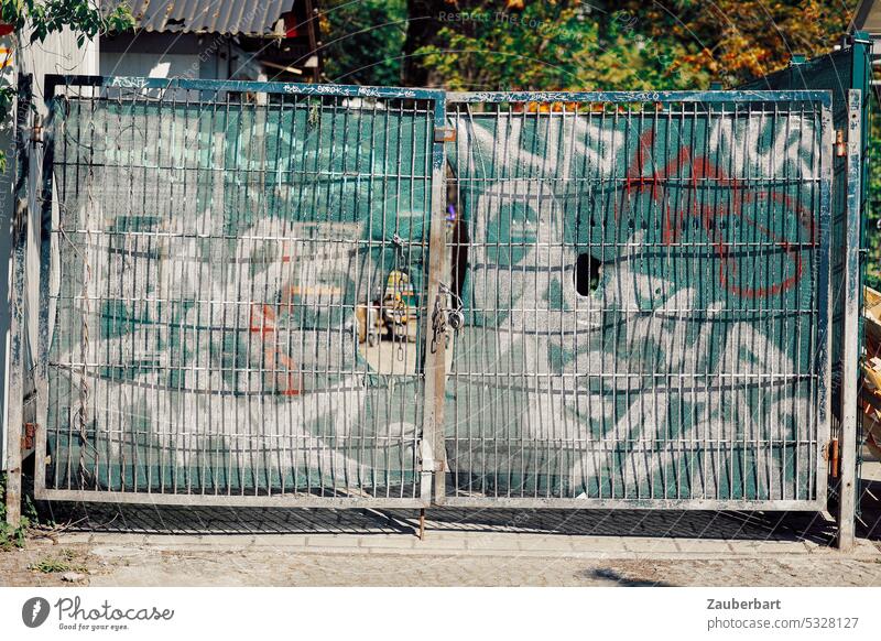 Geschlossenes Stahltor mit Plane zum Sichtschutz, darauf Graffiti Tor Hoftor geschlossen Muster Kontrast hässlich öde trist urban Vandalismus Kunst Raum