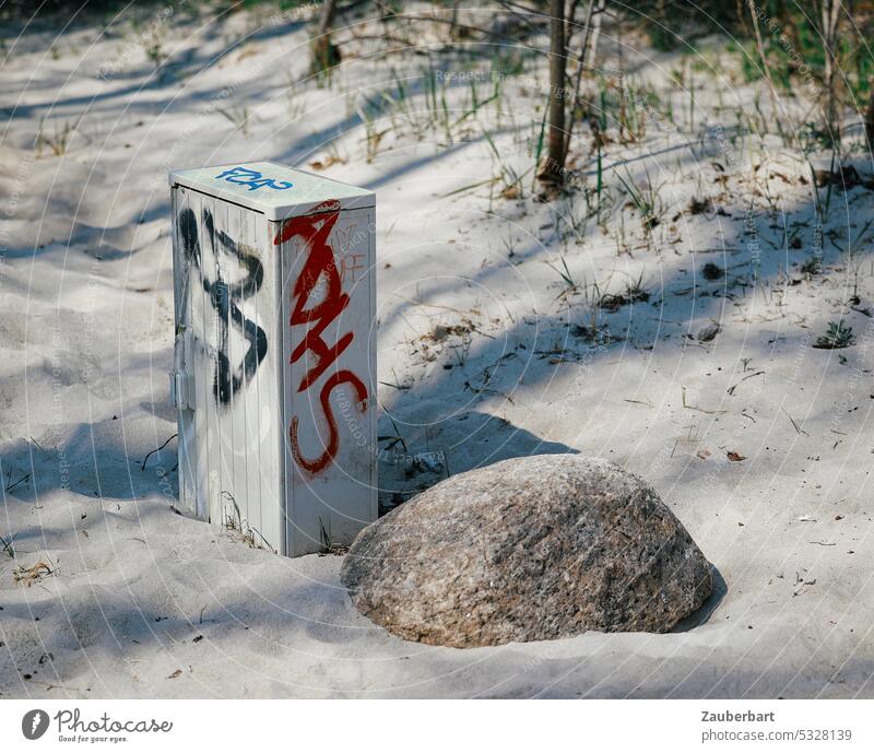 Schaltkasten mit Graffiti steht neben Findling am Strand Sand Schatten Sonne Widerspruch Technik Natur Verschandelung störend Störung Ernüchterung Wirklichkeit