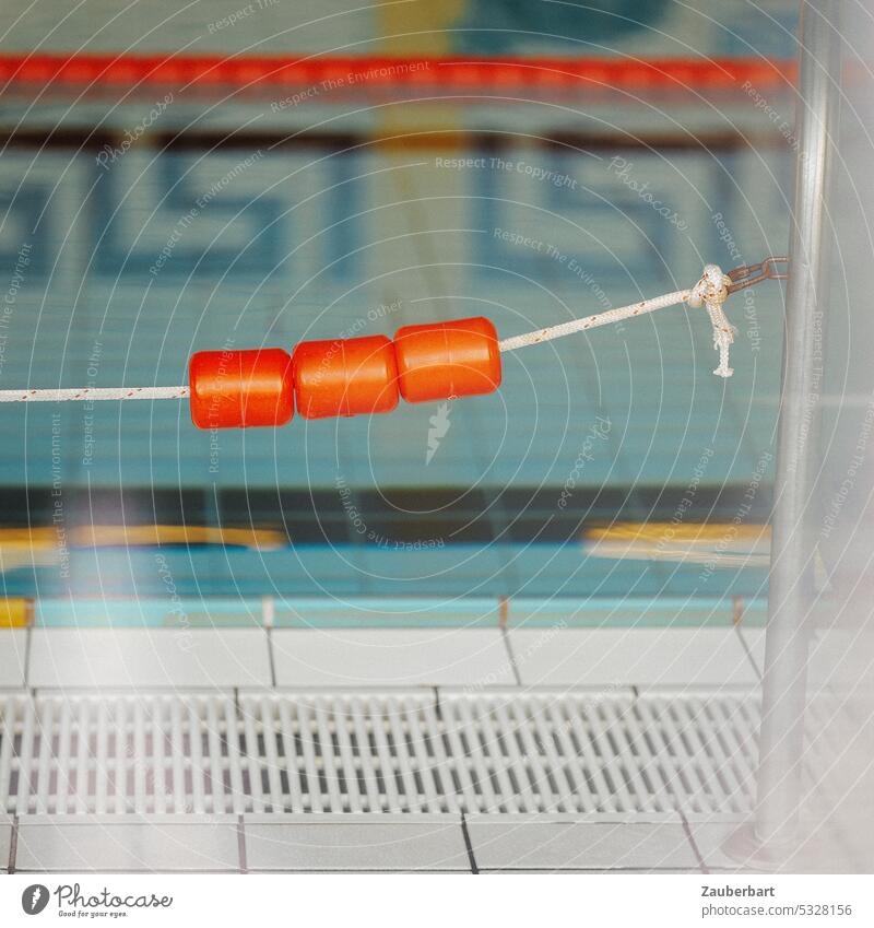 Detail eines Schwimmbads, Schwimmkörper in orange, Schwimmbecken und gespiegeltes Muster Badeanstalt Schwimmbahn Seilschwimmer schwimmen Wasser Pool Stadtbad
