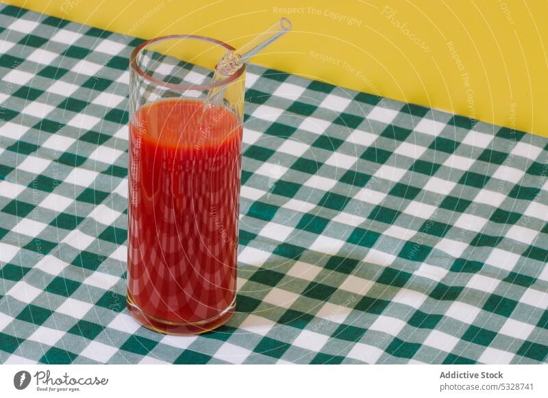 Glas erfrischender Tomatensaft mit Strohhalm Saft kariert umweltfreundlich keine Verschwendung Tischwäsche hell reif Cocktail natürlich wiederverwenden