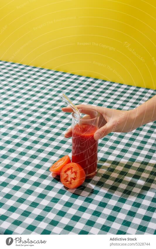 Person, die ein Glas Tomatensaft trinkt Tischwäsche Saft Gemüse Erfrischung organisch reif Vitamin gesunde Ernährung Stroh umweltfreundlich keine Verschwendung
