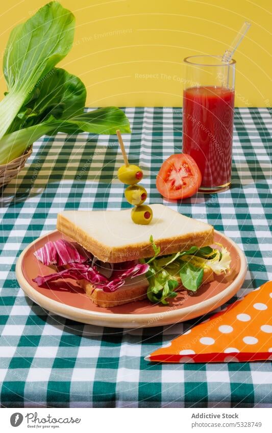Leckerer Smoothie und gesundes Sandwich auf kariertem Tischtuch Belegtes Brot Salatbeilage Tomate Saft gesunde Ernährung Erfrischung Gesundheit Lebensmittel