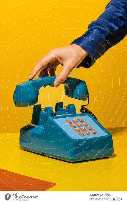 Person legt Telefon auf gelbem Hintergrund auf aufhängen Mobilteil retro ruhend Vorrat altmodisch altehrwürdig kreativ Schaltfläche Draht Gerät Apparatur Tisch
