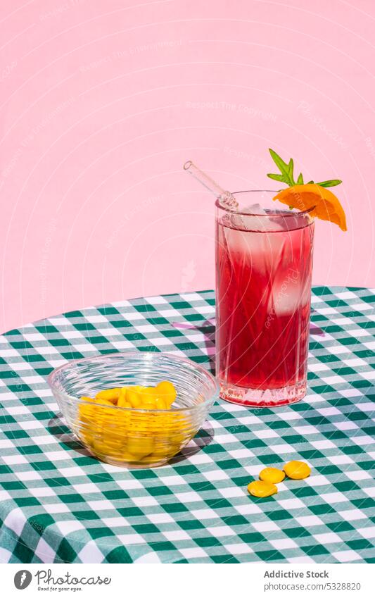 Glas roter Cocktail neben Schüssel mit Lupinenbohnen trinken Getränk orange Erfrischung Tisch dienen Eis kalt Stroh lecker kariert Zitrusfrüchte Frucht Alkohol