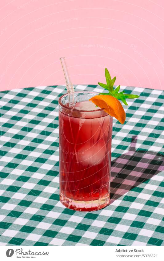 Glas roter Cocktail mit Orangenscheibe trinken Getränk orange Erfrischung Tisch dienen Eis kalt Stroh lecker kariert Zitrusfrüchte Frucht Alkohol Scheibe