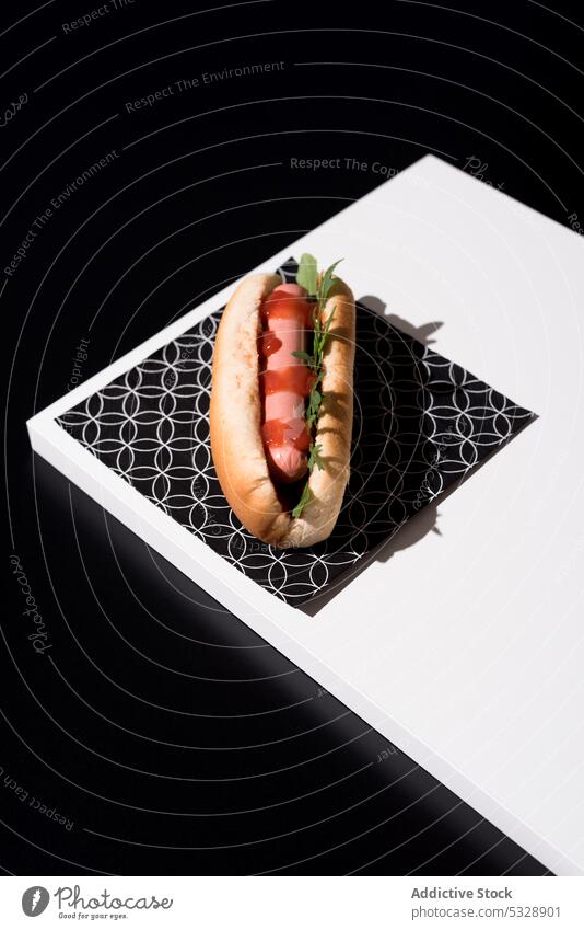 Appetitlicher Hot Dog auf Serviette über schwarzem Tisch Hotdog lecker Fastfood organisch frisch sehr wenige Kontrast Wurstwaren Ketchup Lebensmittel süß