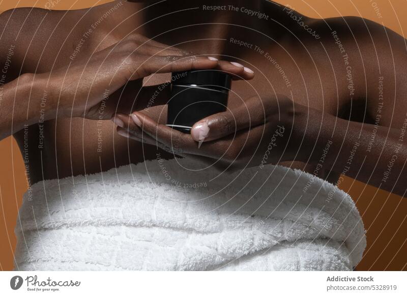 Crop schwarze Frau zeigt kosmetisches Produkt Flasche Sahne Hautpflege Feuchtigkeit manifestieren zeigen Attrappe inserieren Schönheit Lotion Kosmetik