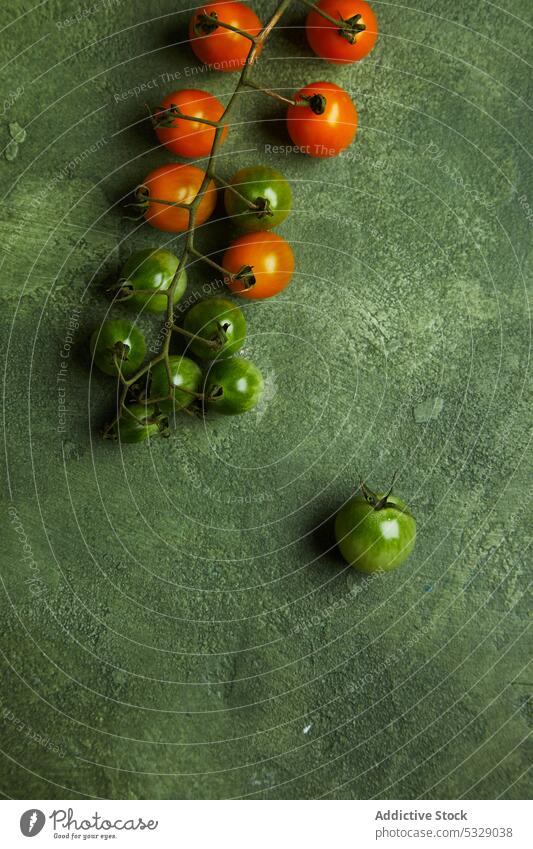 Verschiedene frische Kirschtomaten auf grüner Oberfläche Kirsche Tomate unreif Haufen roh natürlich organisch Gemüse Ernte Lebensmittel Gesundheit geschmackvoll