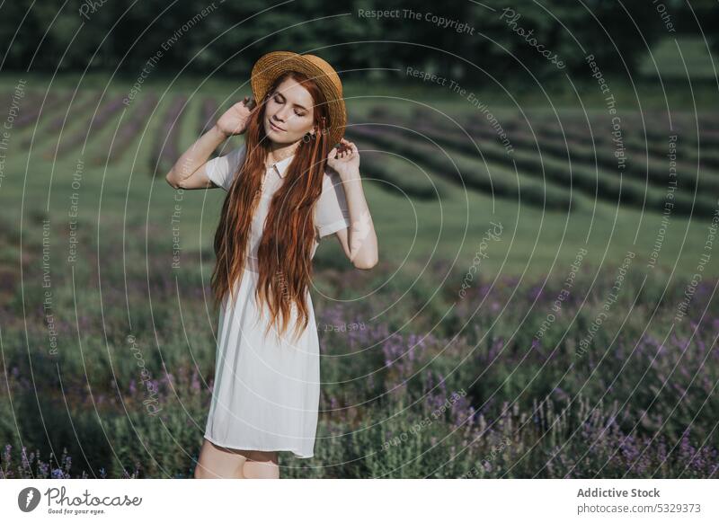 Frau mit Blumen in einem Feld auf dem Land Natur Lavendel Wiese Blüte Blütezeit Landschaft rote Haare feminin Kleid Augen geschlossen jung elegant weißes Kleid