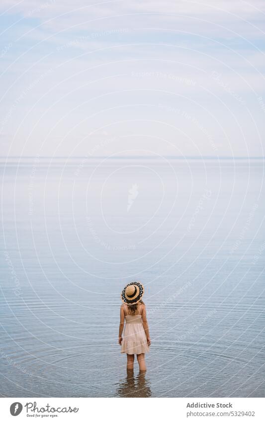 Frau mit Sonnenhut bewundert Meereslandschaft Tourist bewundern Ufer sich[Akk] entspannen Kälte wolkig Model Hut reisen Ausflug Reise erkunden Sommer Urlaub