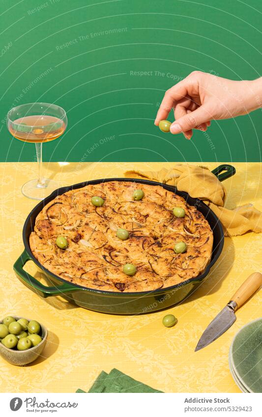 Unbekannte Person legt grüne Oliven auf Brot Ofen vorbereiten oliv Koch Wein Lebensmittel Küche Pfanne Glas Rezept kulinarisch Mahlzeit Feinschmecker dienen