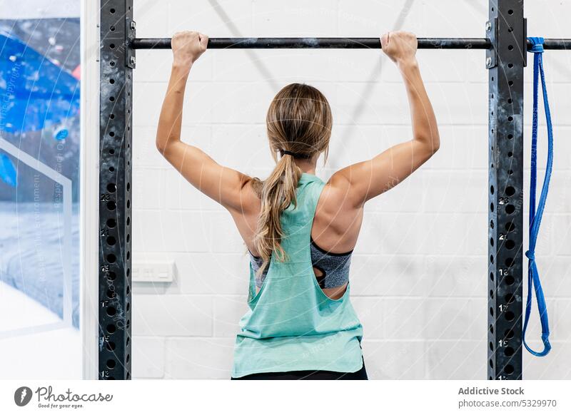 Frau macht Klimmzüge an der Stange Fitnessstudio stark Training Bar Sportlerin Übung Sportbekleidung Athlet Gesundheit Wellness anstrengen Wohlbefinden Kraft