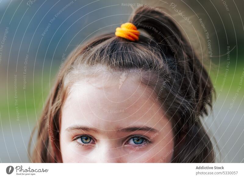 Crop Mädchen Kind mit Pferdeschwanz Haar mit gelben Haarband Leitwerke unschuldig charmant Behaarung Kindheit bezaubernd braunes Auge Starrer Blick niedlich
