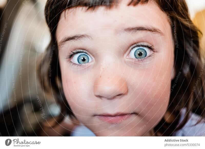 Nettes Mädchen schaut in die Kamera auf unscharfem Hintergrund Porträt starren Gesicht machen erstaunt Schock Überraschung spielerisch lustig betäuben Kind