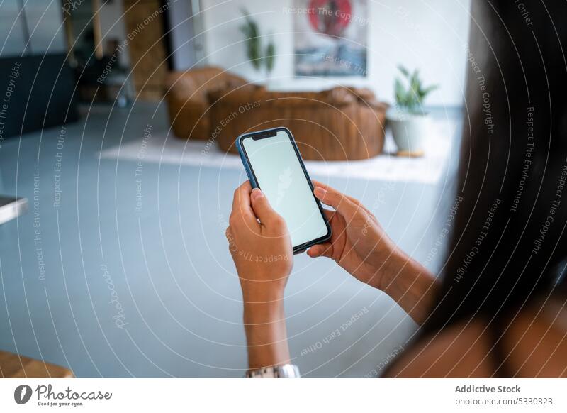 Anonyme Frau benutzt Smartphone auf der Ledercouch zu Hause Sofa heimwärts Wohnzimmer Browsen Mobile Telefon benutzend Apparatur ruhen online Gerät Internet