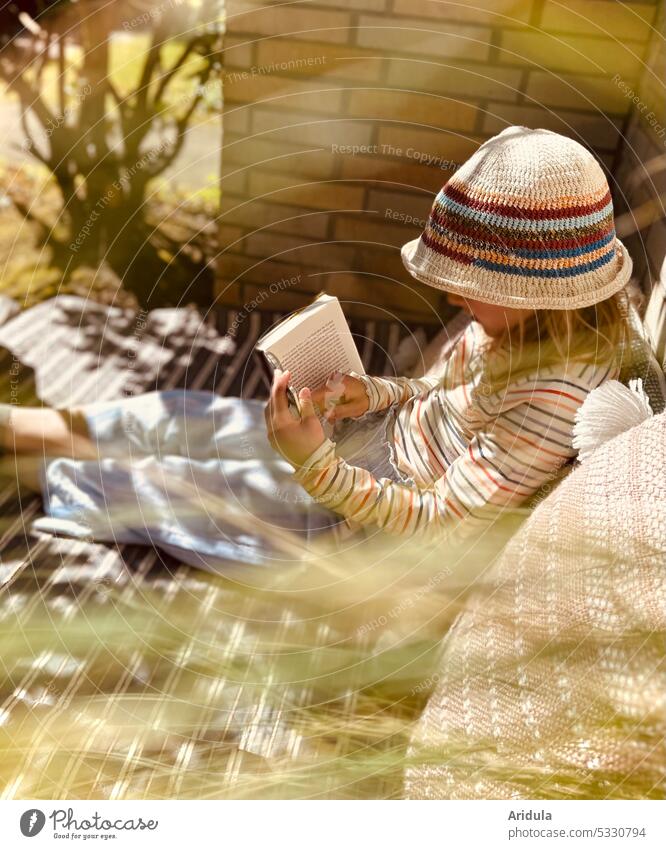 Mädchen hat es sich mit einem Buch gemütlich gemacht lesen Garten Ecke Strickhut Mütze Sonnenlicht Licht Schatten Reflexion & Spiegelung Unschärfe Außenaufnahme
