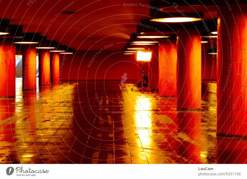 Scheinwerfer an - Catwalk unter Tage Unterführung Lichter nass Spiegelung Säulen Wasser Beleuchtung orange menschenleer Reflexion & Spiegelung dunkel Lampe