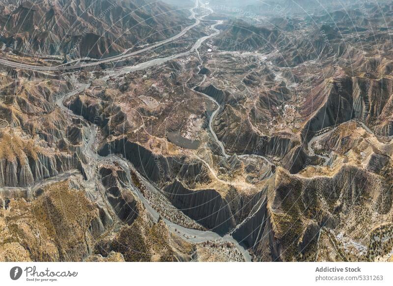 Drohnenansicht von rauen felsigen Bergen mit trockenem Fluss bei Tageslicht Hochland Natur Tal Dürre Berge u. Gebirge uneben wüst Kamm unfruchtbar Gelände