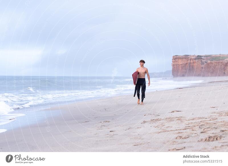 Entfernter Surfer auf sandigem Küstenstreifen Mann Strand Lächeln Surfbrett Sonnenuntergang MEER froh Urlaub Sommer winken Feiertag Glück männlich Meer